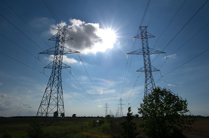 Two transmission line towers and a blue sky.